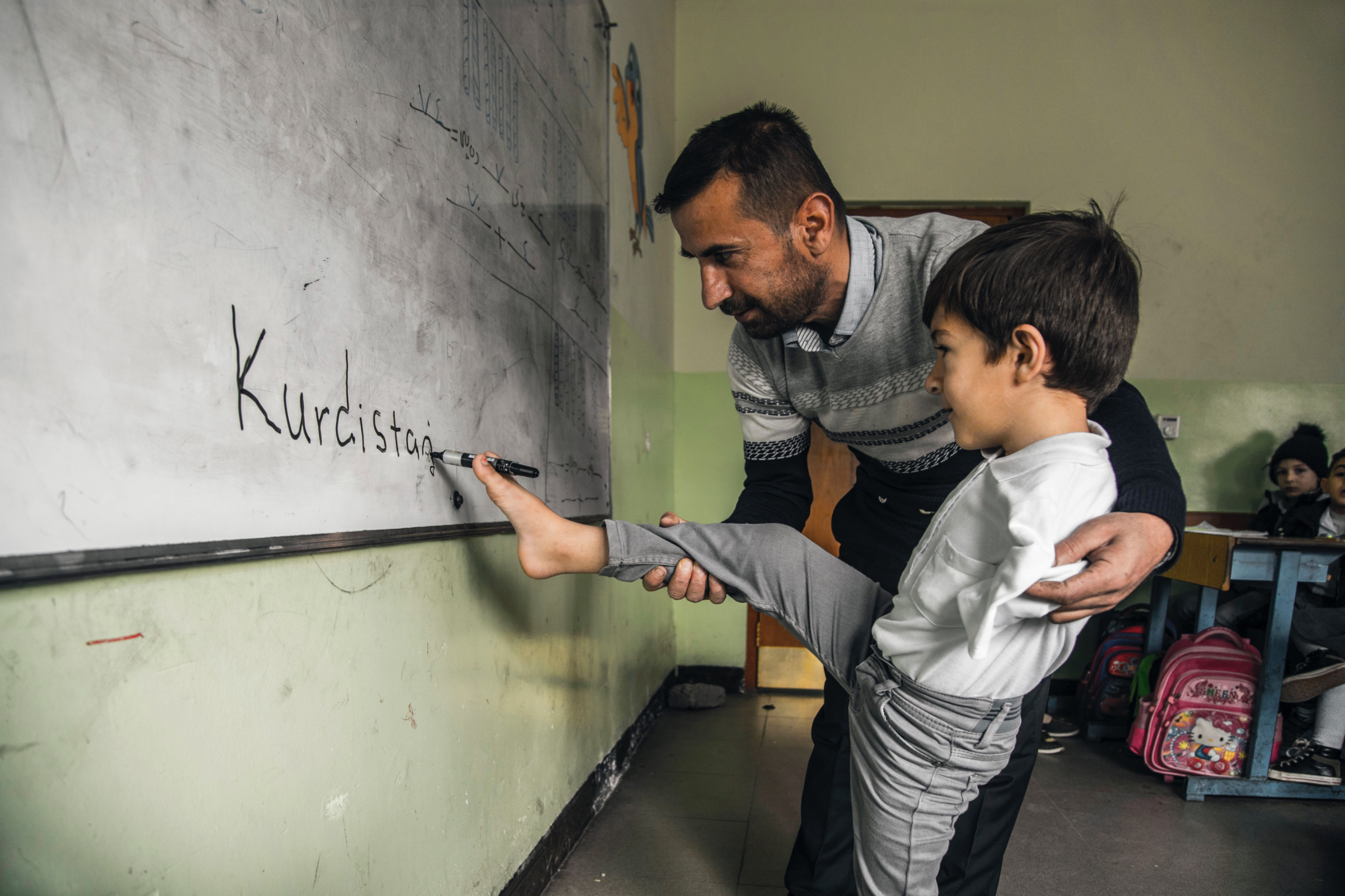 6-year_old_Koshyar_who_does_not_have_arms_writes_the_word Kurdistan with his legs