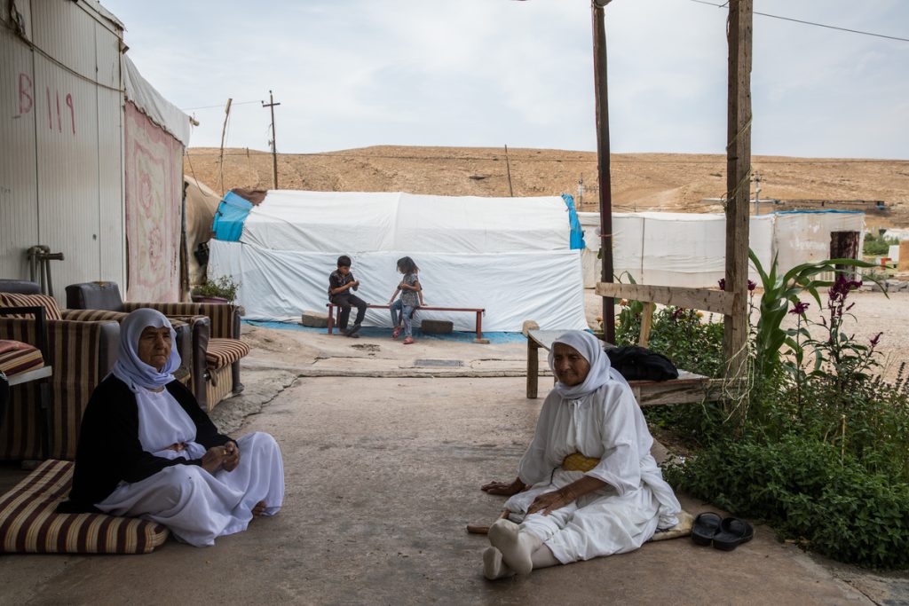 Women sitting in a Yazidi camp in Iraq