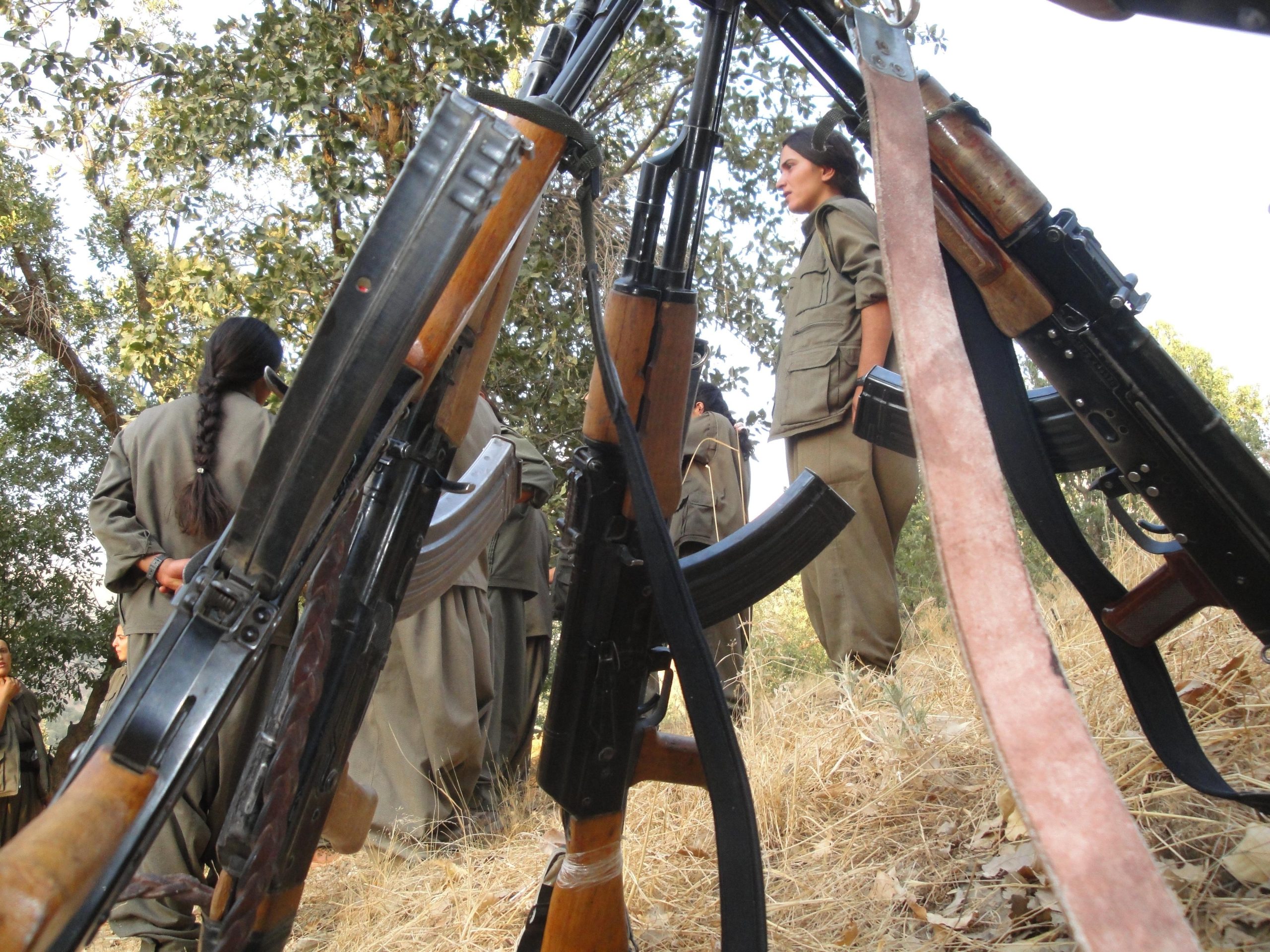 Picture of guns and a female person in combat fatigues
